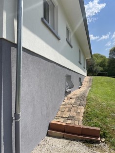 Façade rénovée, enduit clair et soubassement gris